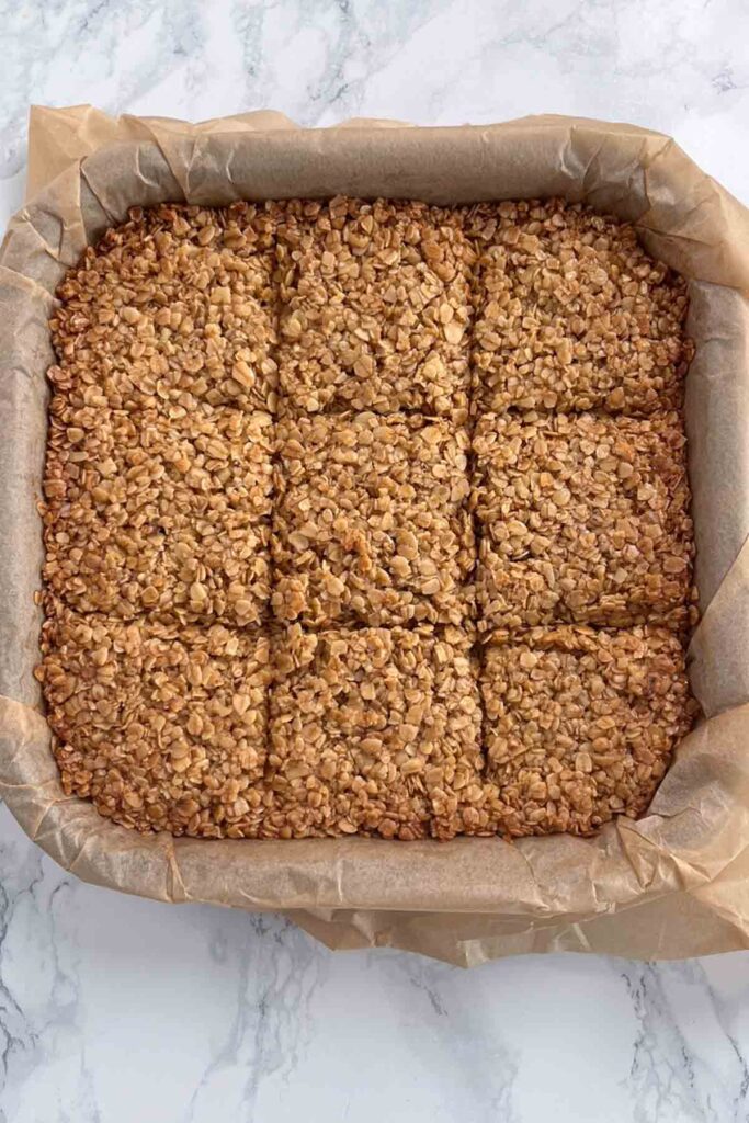 baked oat bars in a tin with score marks
