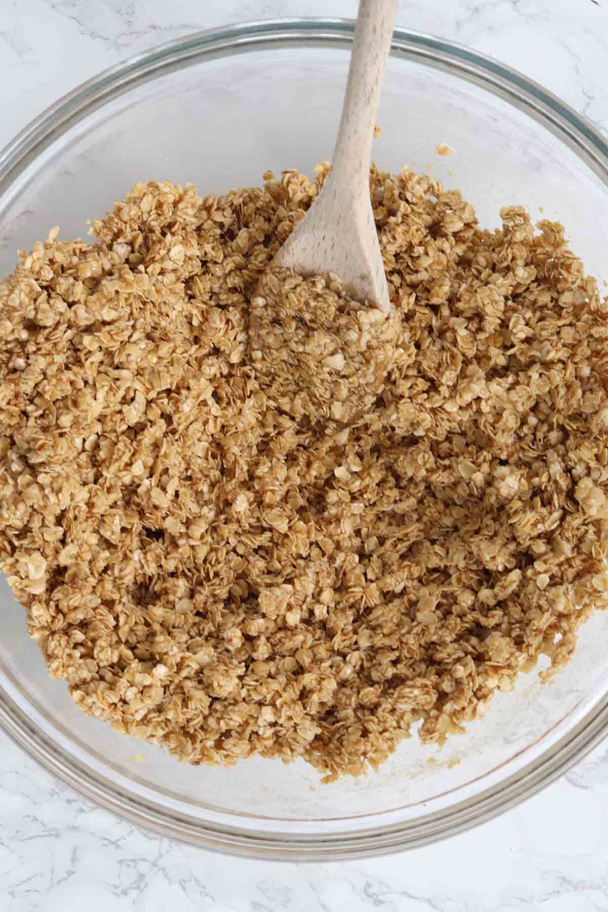 golden syrup and butter mixture mixed with oats in a bowl