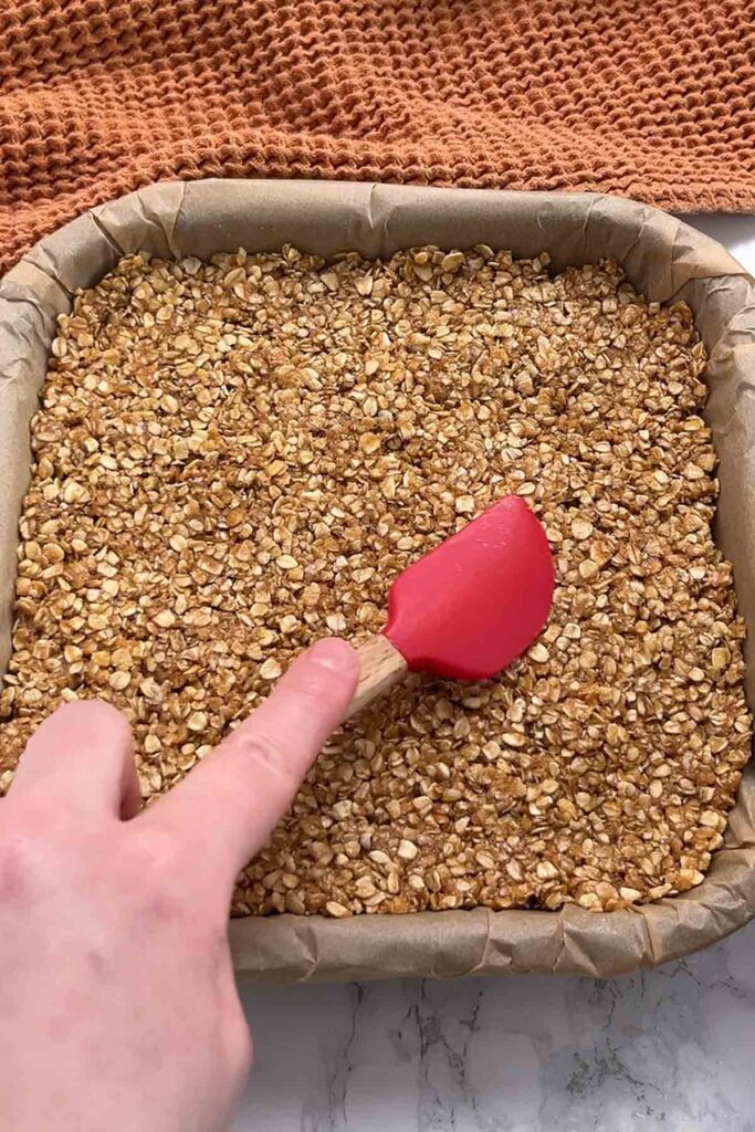 pressing the mixture into the lined tin