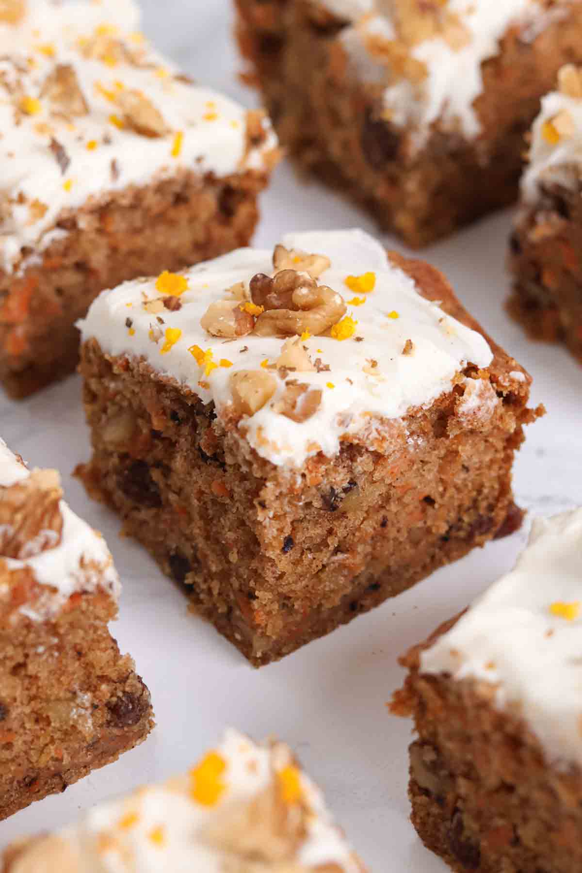 slices of carrot cake traybake cake on a white worktop