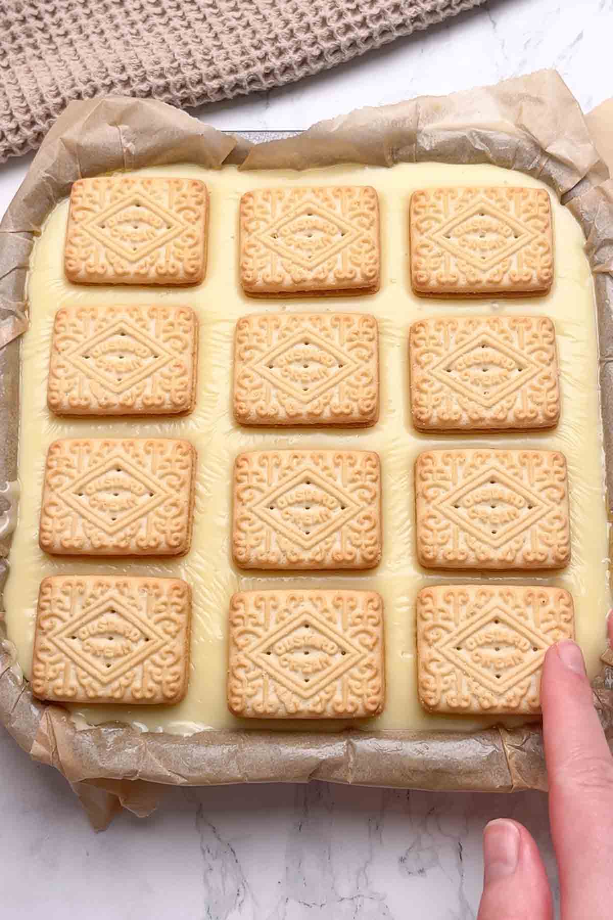 placing biscuits on top of the white chocolate fudge topping