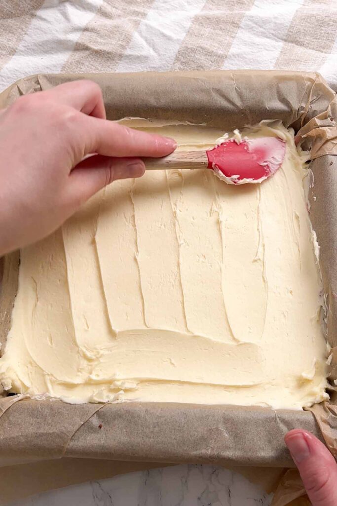 spreading the vanilla buttercream on top