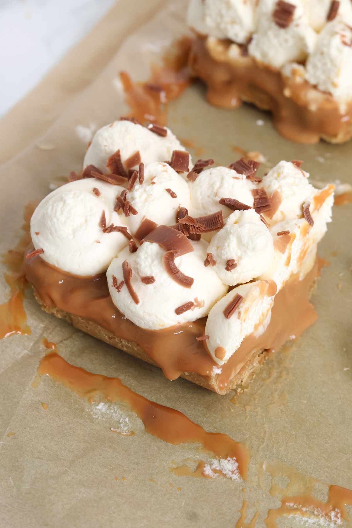 bars of no bake banoffee pie traybake on a sheet of baking paper