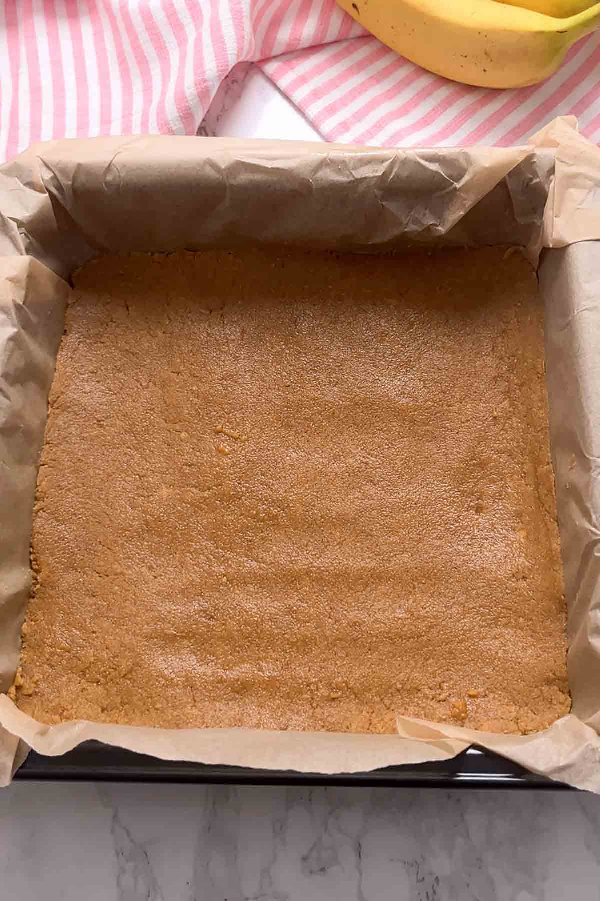 digestive biscuit base pressed into the bottom of a lined tin