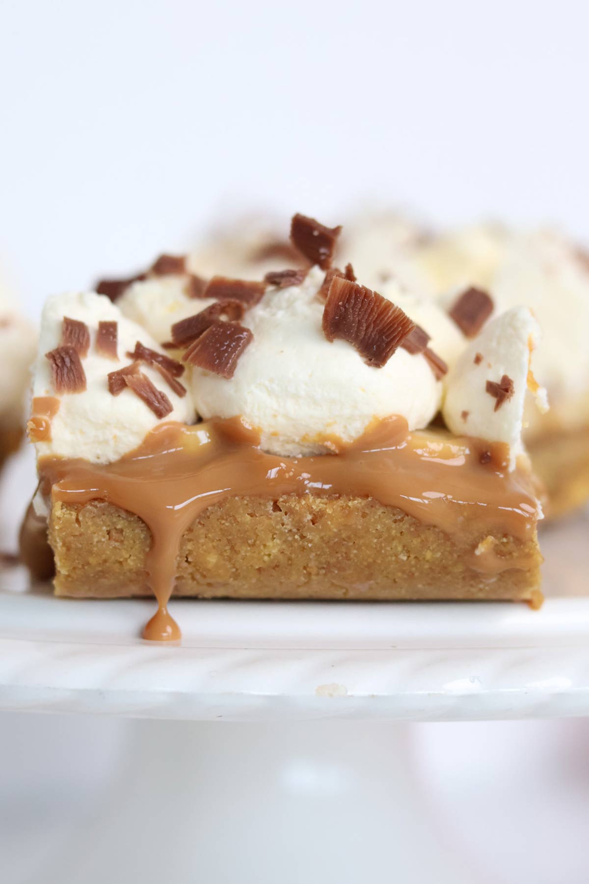 slices of banoffee pie bars traybake on a white cake stand