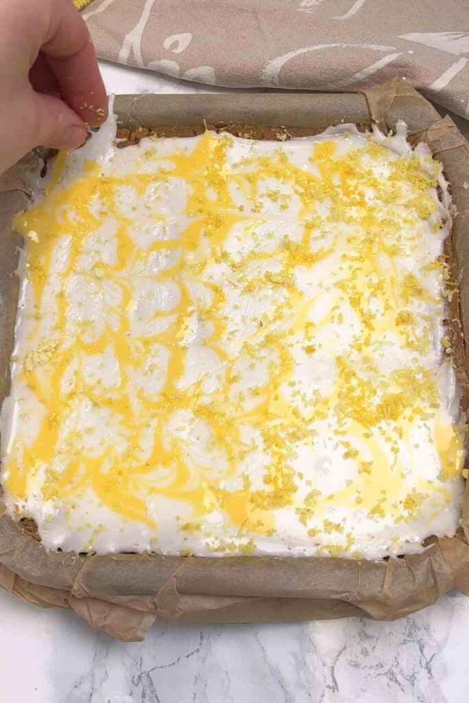 decorating the lemon traybake with lemon zest
