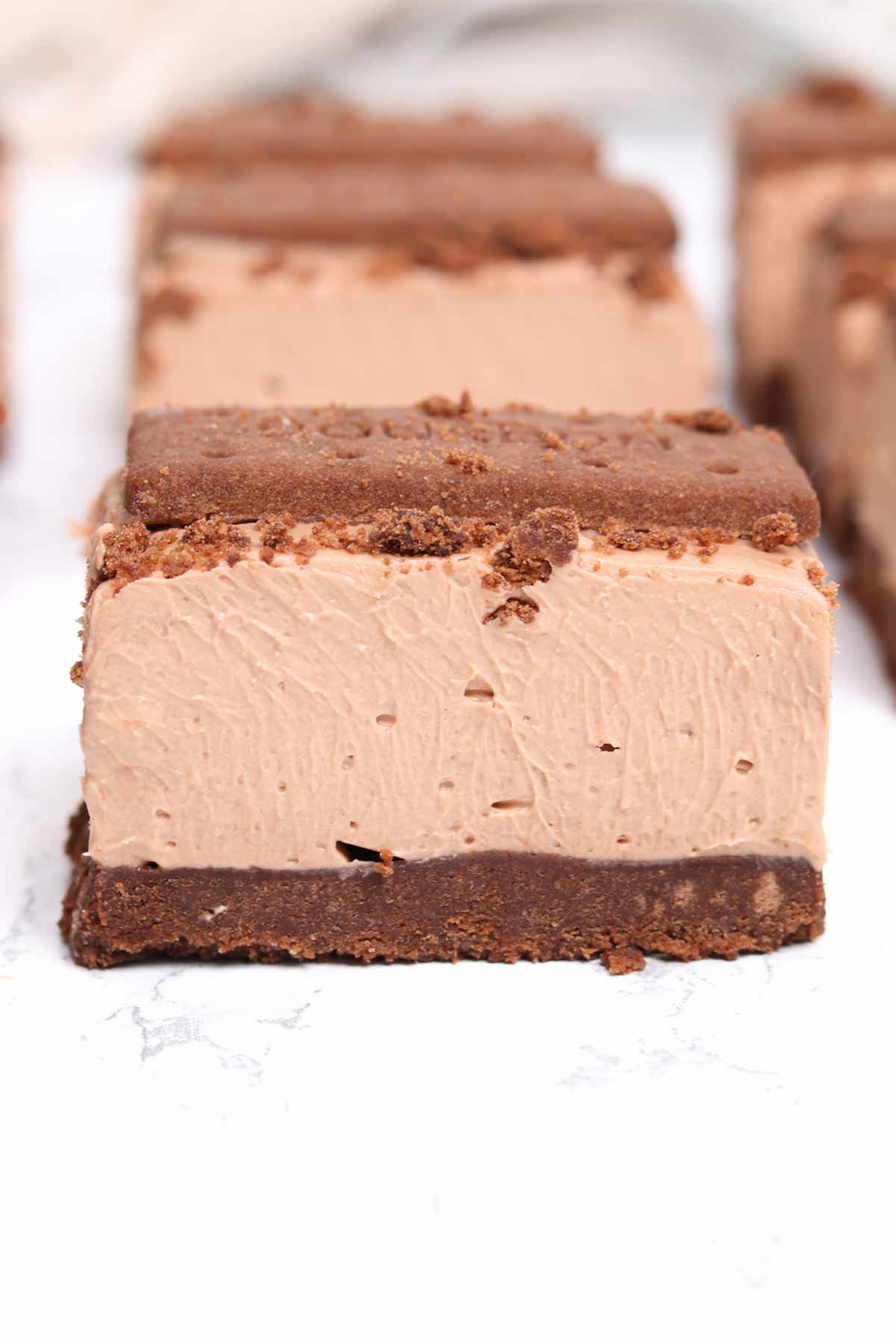 no bake bourbon biscuit cheesecake bars on a white surface