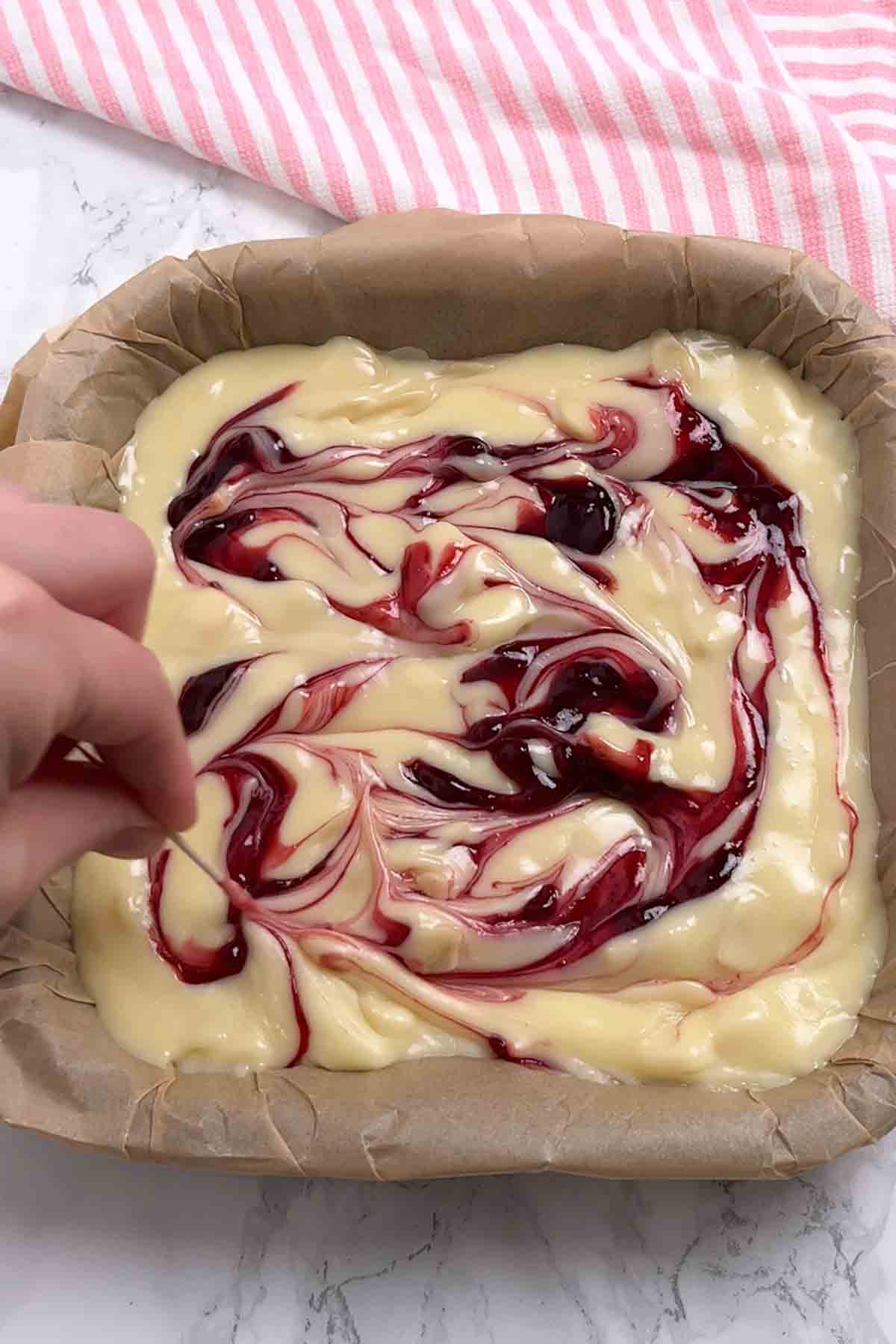 swirling cherry jam into the almond fudge mixture